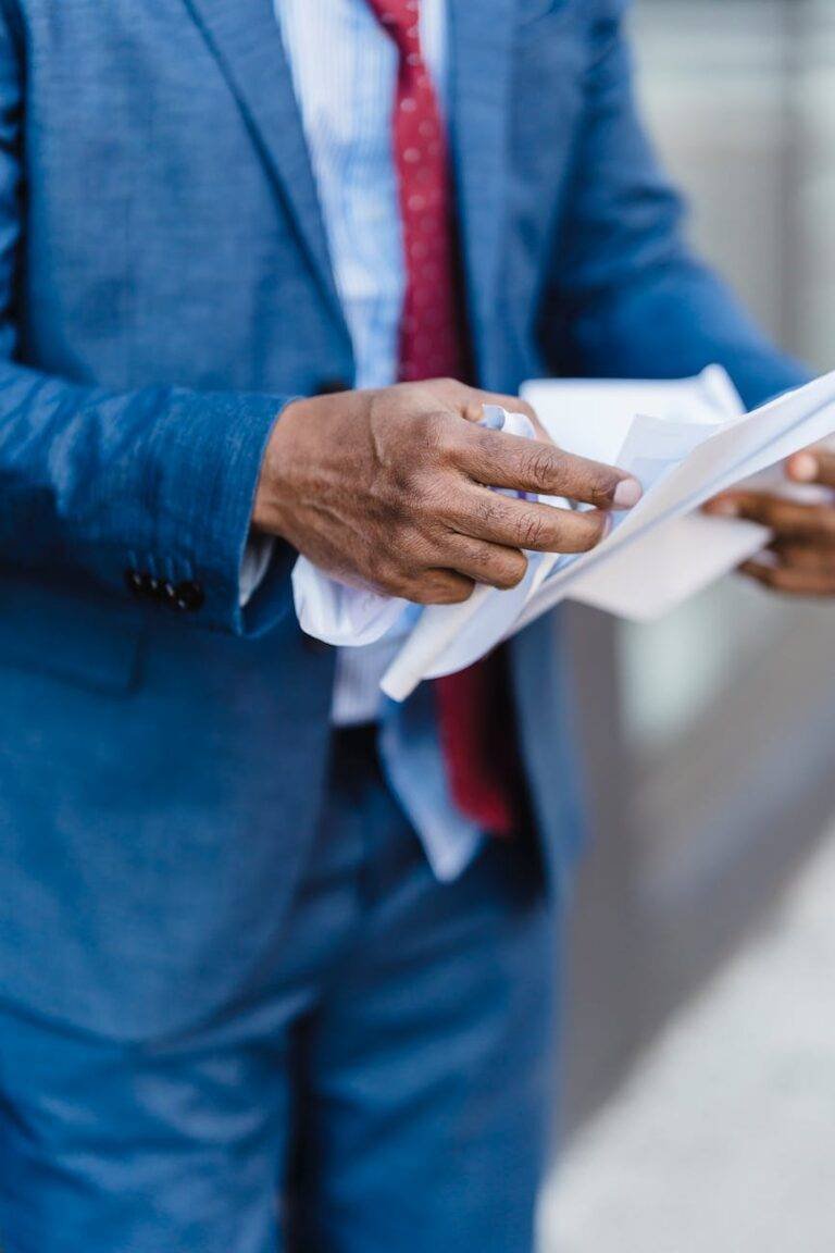 unrecognizable businessman with documents on street
