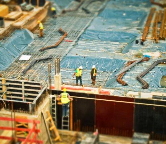 man in yellow safety vest climbing on ladder