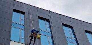 low angle shot of people cleaning the windows in a modern building in city