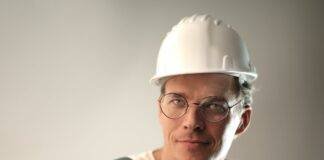 smiling male worker in construction helmet in studio
