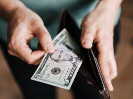 unrecognizable man holding wallet with money