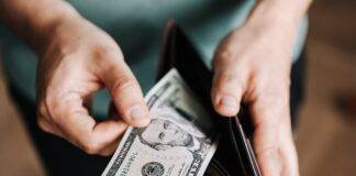 unrecognizable man holding wallet with money