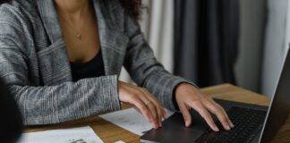 a woman in plaid blazer using her laptop