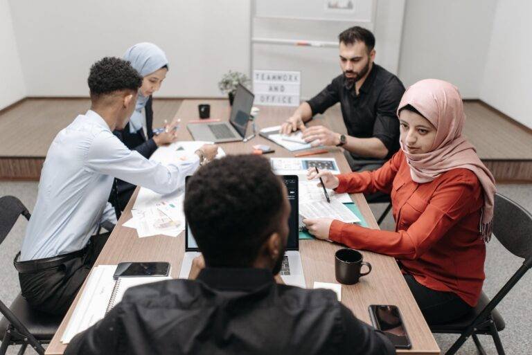 group of coworkers sitting around a table in a meeting