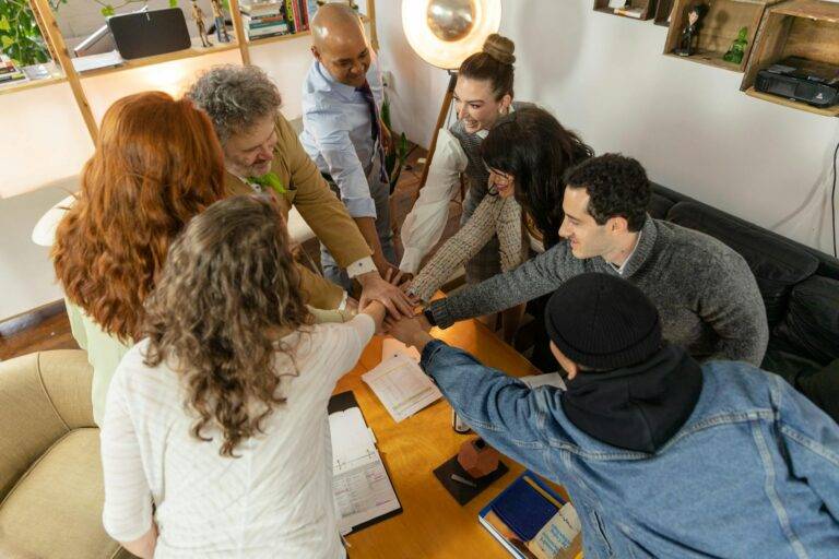 coworkers putting their hands together during a meeting