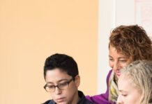 closeup photo of three person looking at macbook air