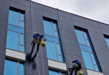 low angle shot of people cleaning the windows in a modern building in city
