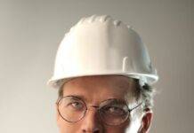 smiling male worker in construction helmet in studio