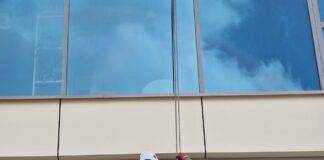 a man cleaning the windows of a skyscraper on a high floor