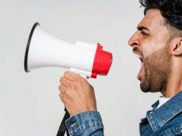 man in blue denim jacket holding a megaphone