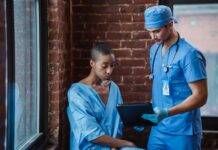 doctor demonstrating diagnosis to pensive black patient in corridor of hospital