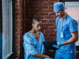 doctor demonstrating diagnosis to pensive black patient in corridor of hospital