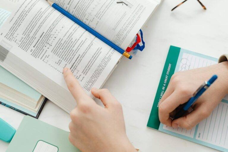 person studying and writing notes on paper