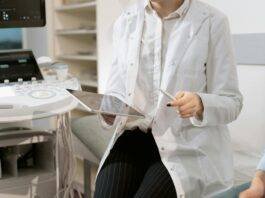 photo of gynecologist sitting near medical equipment