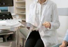photo of gynecologist sitting near medical equipment