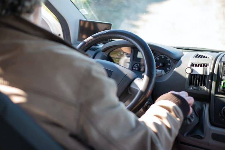 person in white long sleeve shirt driving car
