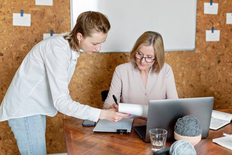 women looking at documents and talking in an office