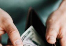 unrecognizable man holding wallet with money