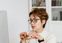 confident elegant lady in eyeglasses hosting webinar