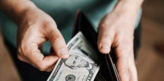 unrecognizable man holding wallet with money