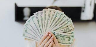 person holding fan of us dollar bills