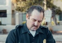 a bearded police man writing on paper