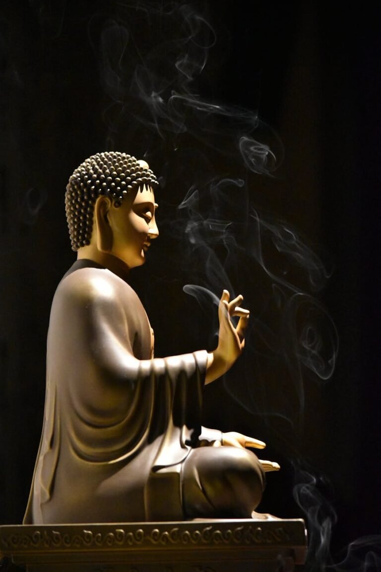 figurine of sitting budda with lit incense