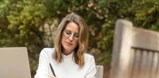 woman sitting on gray chair while writing on table