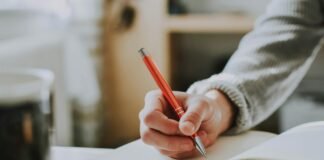person holding orange pen