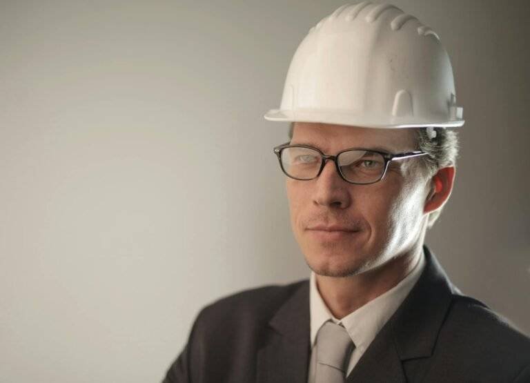 man in black suit jacket wearing hard hat