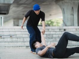 young asian man helping friend on pavement
