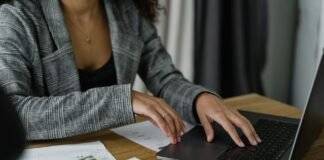 a woman in plaid blazer using her laptop