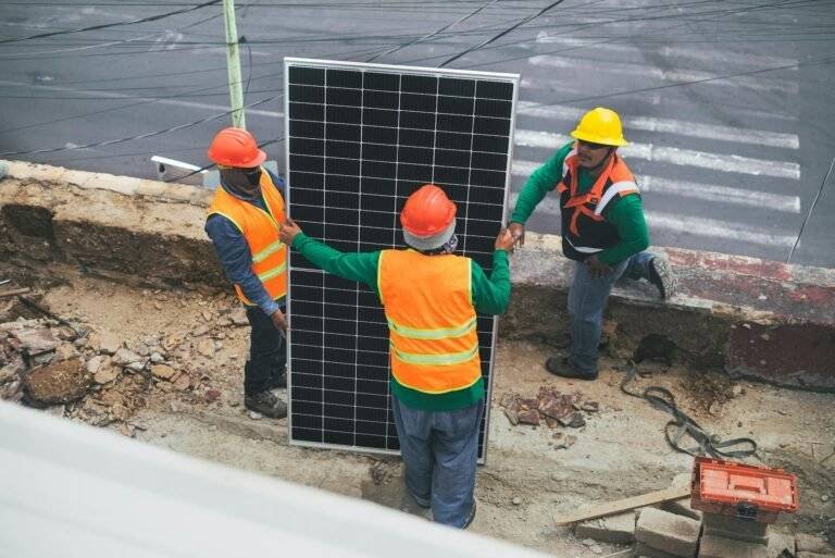 solar technicians holding solar panel