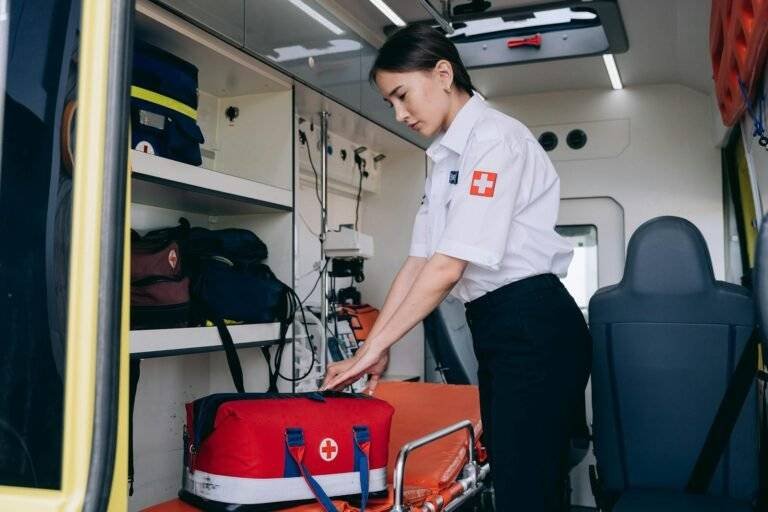 paramedic standing at the back of an ambulance with a bag