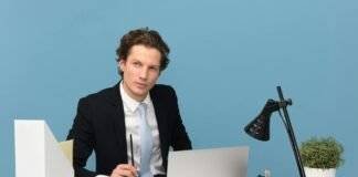 man sitting with laptop computer on desk and lamp