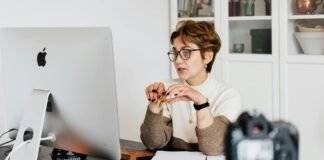 confident elegant lady in eyeglasses hosting webinar