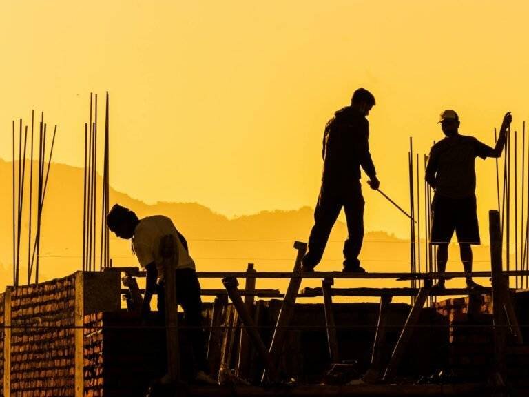silhouette of construction workers at sunset