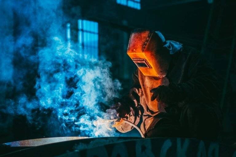 person welding wearing a prootective metal mask