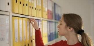 pondering female secretary picking folder in workplace