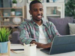 smiling man working on laptop