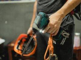 crop repairman standing with working screwdriver and orange helmet