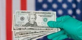 banknotes of american dollars in hand against flag