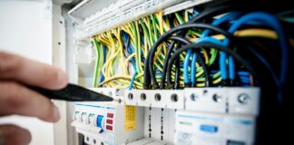 electrician fixing an opened switchboard