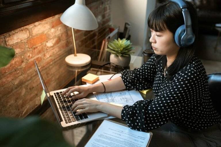 woman in black and white polka dot long sleeve shirt using macbook air