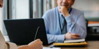 woman filling job application form in office with boss