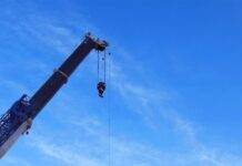 crane machinery loading on a truck on a construction site