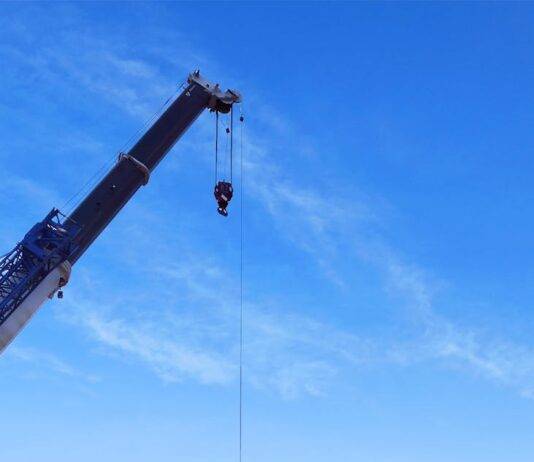 crane machinery loading on a truck on a construction site