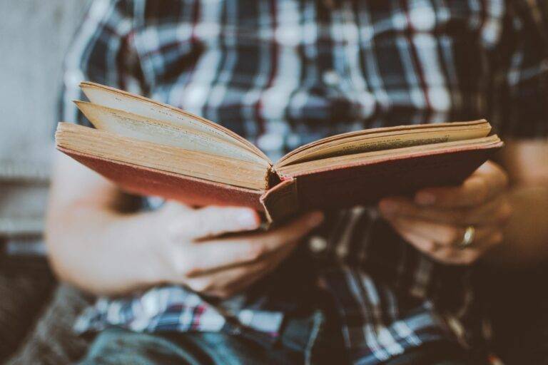 person reading book while sitting