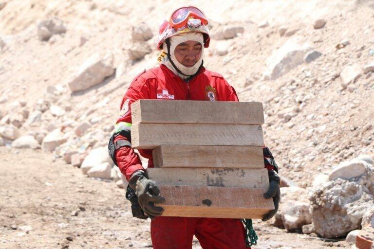 rescue worker carrying wooden planks in moquegua