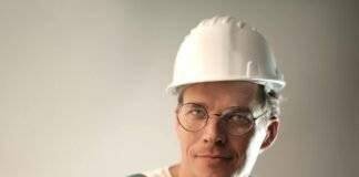 smiling male worker in construction helmet in studio